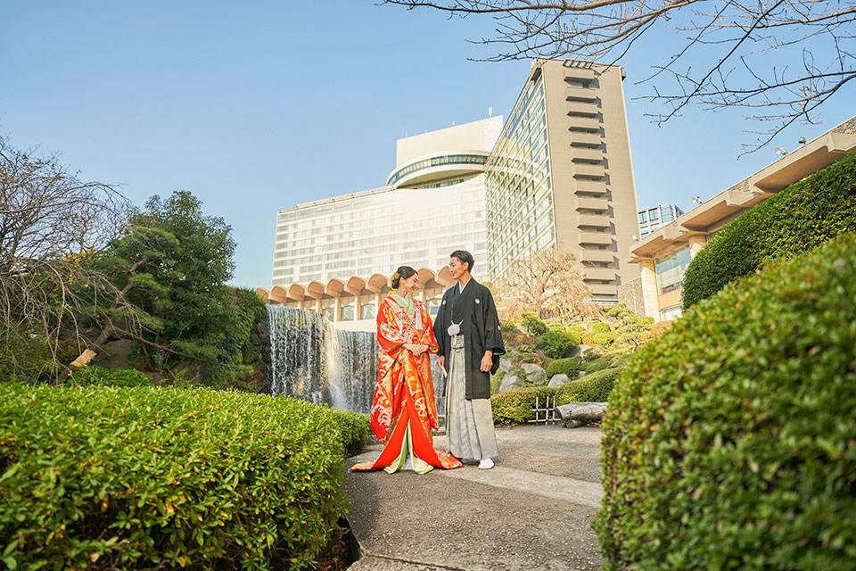日本庭園で記念撮影する和装の新郎新婦の様子