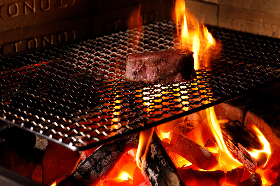 炭火で調理される肉料理