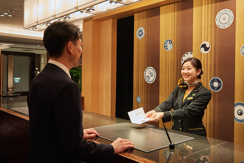 ホテルフロントでのスタッフとゲストの写真