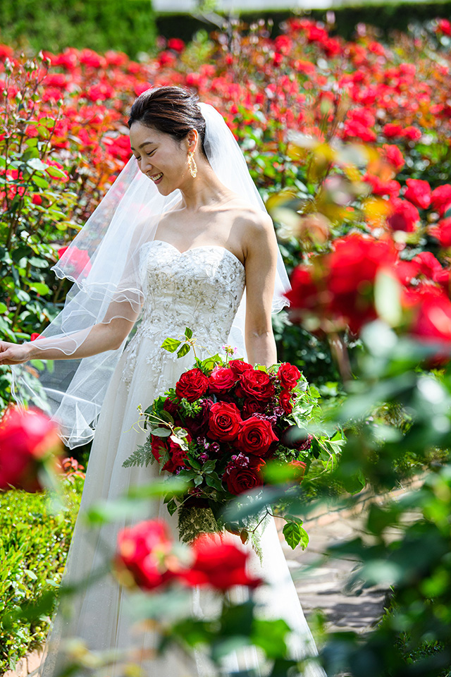 ローズガーデンで薔薇のブーケを持った新婦