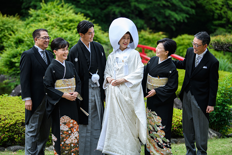 日本庭園で記念撮影する夫婦とその親族の様子