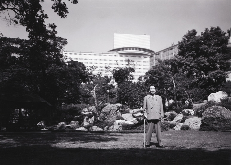 創業者 大谷米太郎が日本庭園に立つ写真